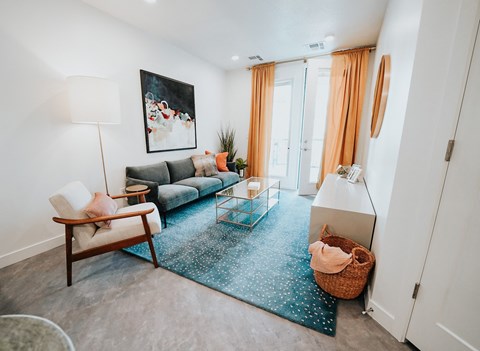 a living room with a blue rug and a couch